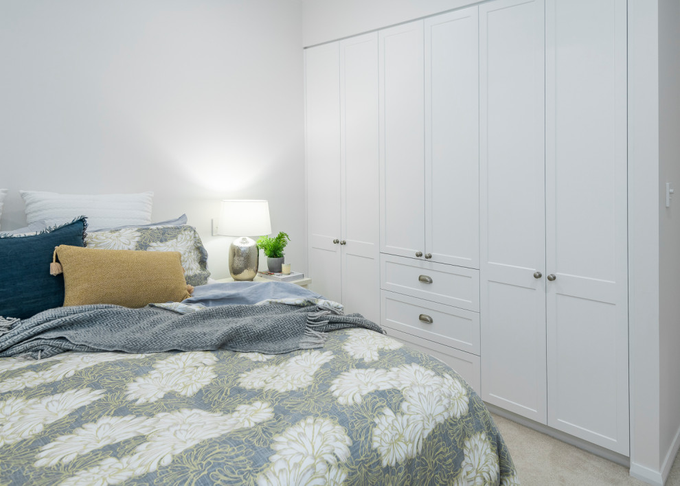 Inspiration for a mid-sized transitional guest bedroom in Brisbane with white walls, carpet and beige floor.