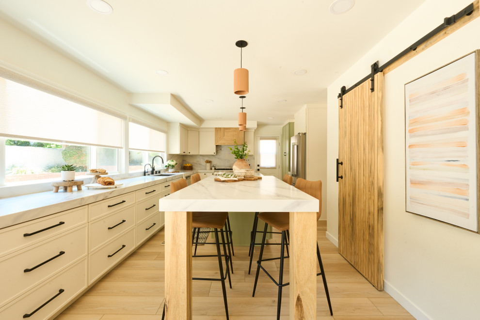 Inspiration for a large transitional u-shaped vinyl floor and brown floor eat-in kitchen remodel in Orange County with an undermount sink, shaker cabinets, white cabinets, quartz countertops, white backsplash, quartz backsplash, stainless steel appliances, two islands and white countertops
