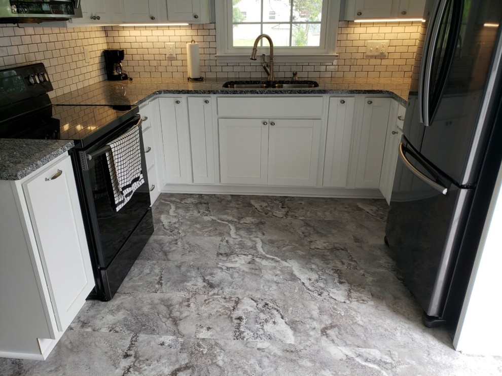 Inspiration for a small rustic u-shaped vinyl floor and gray floor enclosed kitchen remodel with an undermount sink, shaker cabinets, white cabinets, granite countertops, white backsplash, subway tile backsplash, black appliances, no island and multicolored countertops