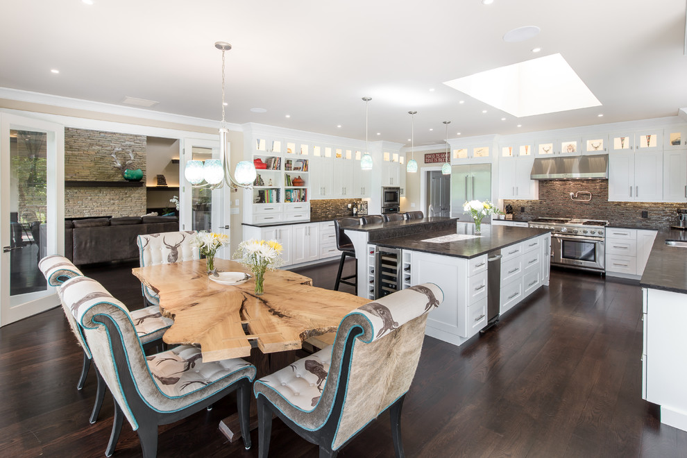 Large transitional u-shaped dark wood floor and brown floor eat-in kitchen photo with a double-bowl sink, shaker cabinets, white cabinets, concrete countertops, brown backsplash, matchstick tile backsplash, stainless steel appliances, an island and gray countertops