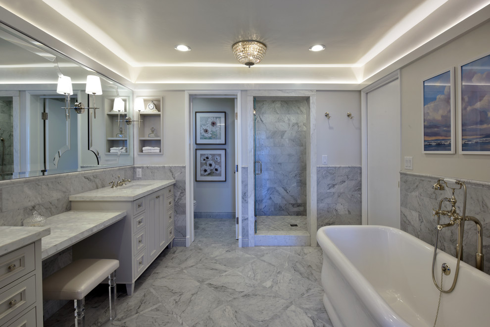 Inspiration for a mid-sized traditional master bathroom in San Diego with white cabinets, a freestanding tub, an alcove shower, white tile, marble, white walls, marble floors, an undermount sink, marble benchtops, white floor and a hinged shower door.