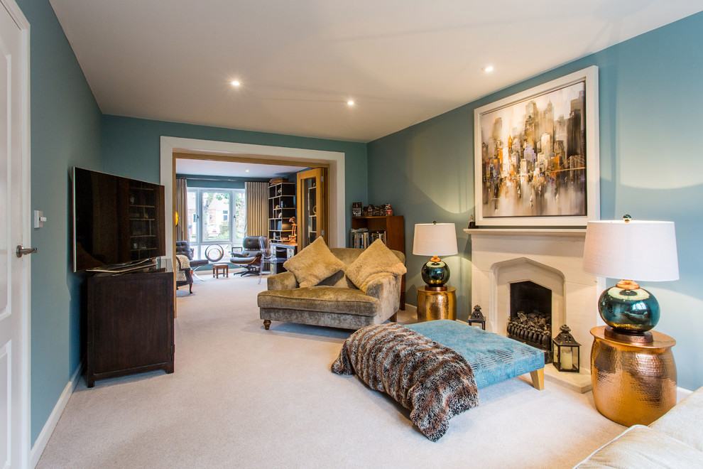 Example of a mid-sized eclectic formal and enclosed carpeted, beige floor, wallpaper ceiling and wallpaper living room design in Oxfordshire with blue walls, a standard fireplace, a concrete fireplace and a tv stand