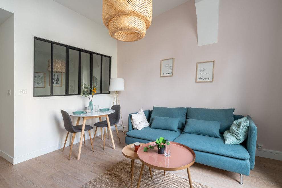 This is an example of a mid-sized contemporary open concept living room in Nantes with pink walls, light hardwood floors, no fireplace, a freestanding tv, beige floor and exposed beam.