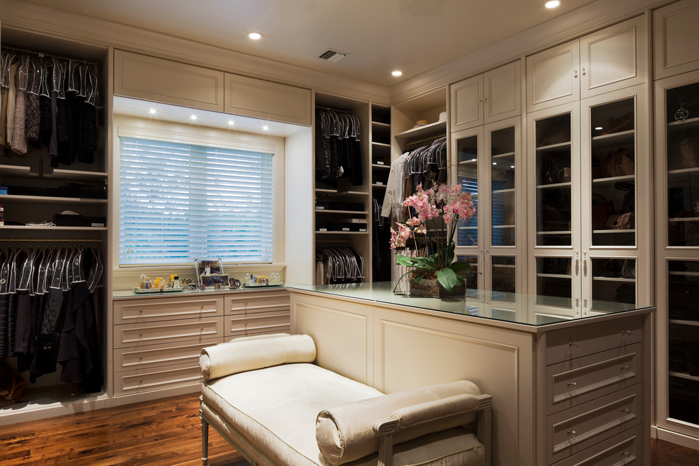 Photo of an expansive traditional gender-neutral walk-in wardrobe in Miami with recessed-panel cabinets, white cabinets, medium hardwood floors, brown floor and recessed.