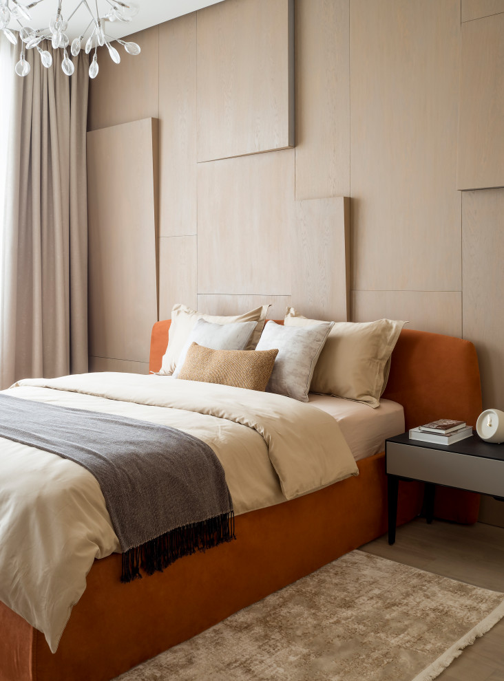 Immagine di una camera matrimoniale contemporanea con pareti arancioni e pavimento in legno massello medio