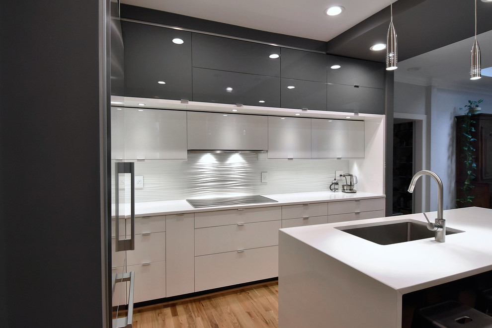 Design ideas for a mid-sized modern eat-in kitchen in Charlotte with an undermount sink, flat-panel cabinets, white cabinets, quartzite benchtops, white splashback, ceramic splashback, stainless steel appliances, light hardwood floors and with island.