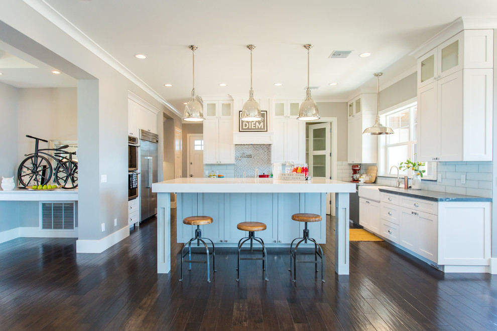 Design ideas for a large transitional u-shaped eat-in kitchen in Phoenix with a farmhouse sink, shaker cabinets, white cabinets, quartz benchtops, glass tile splashback, stainless steel appliances, dark hardwood floors and with island.