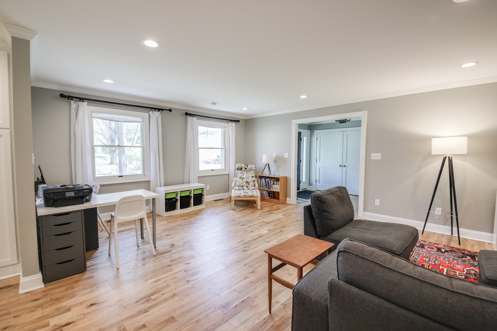 This is an example of a mid-sized contemporary open concept family room in Other with grey walls, light hardwood floors, a standard fireplace, a brick fireplace surround, a wall-mounted tv and brown floor.