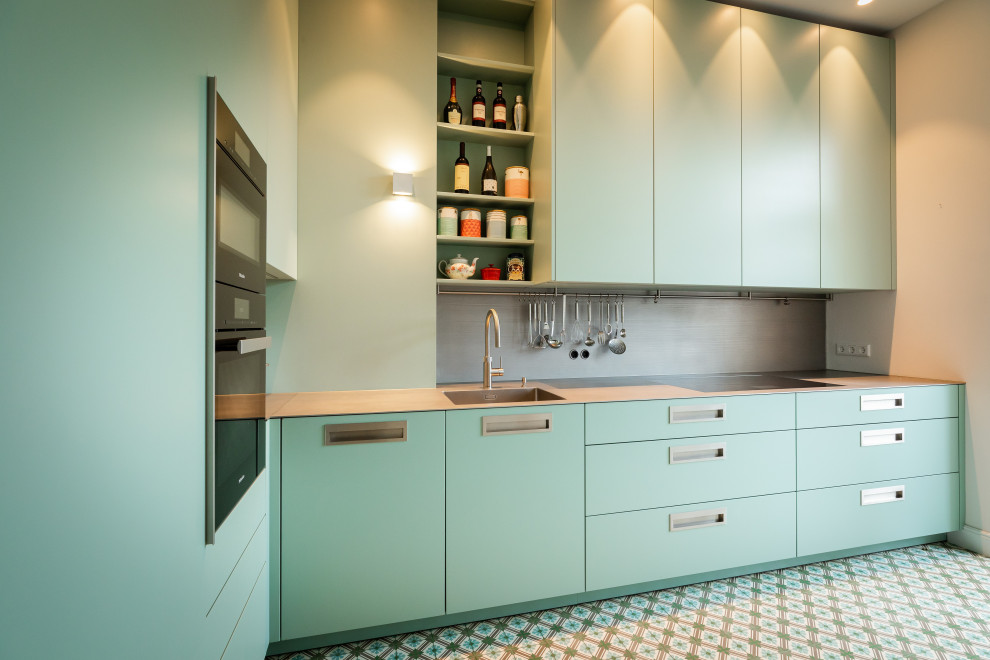 Small contemporary l-shaped separate kitchen in Frankfurt with an integrated sink, flat-panel cabinets, turquoise cabinets, stainless steel benchtops, grey splashback, metal splashback, black appliances, turquoise floor, grey benchtop and no island.