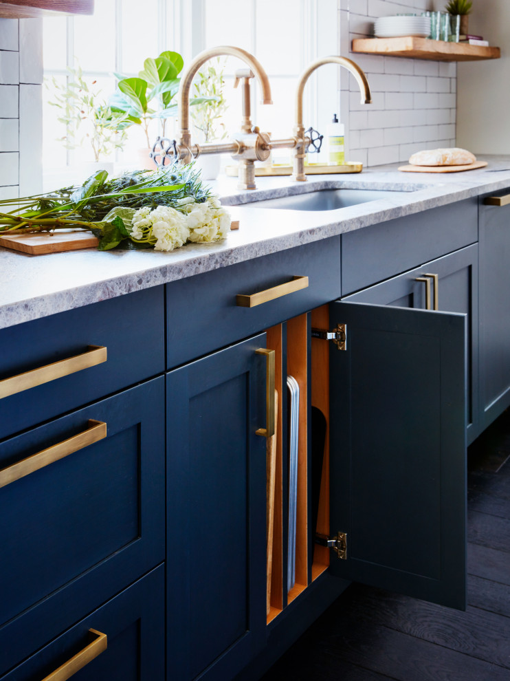 This is an example of a large country galley open plan kitchen in New York with an undermount sink, shaker cabinets, blue cabinets, white splashback, subway tile splashback, coloured appliances, dark hardwood floors, with island, black floor and grey benchtop.