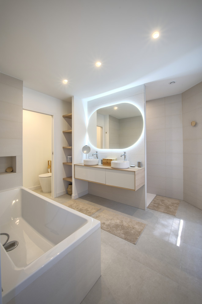Large tropical master bathroom in Montpellier with white cabinets, a two-piece toilet, a vessel sink, grey floor, an enclosed toilet and a double vanity.