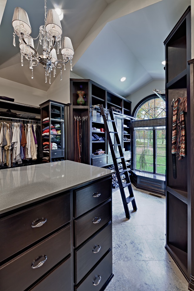 Inspiration for a traditional walk-in wardrobe in Cleveland with dark wood cabinets.