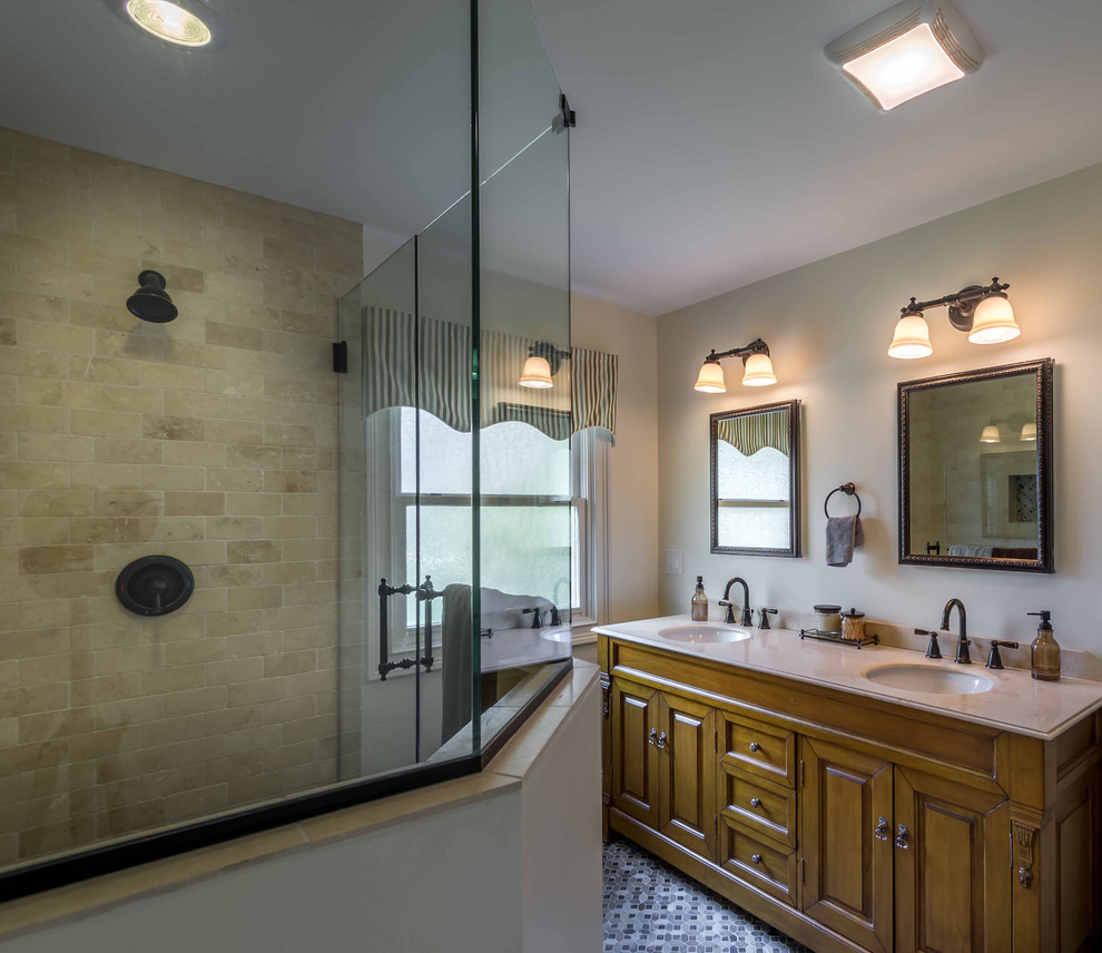 This is an example of a mid-sized traditional master bathroom in Chicago with raised-panel cabinets, medium wood cabinets, a corner shower, a two-piece toilet, white tile, stone tile, white walls, mosaic tile floors, an undermount sink, marble benchtops, multi-coloured floor, a hinged shower door, white benchtops, a double vanity, a floating vanity, wallpaper and wallpaper.