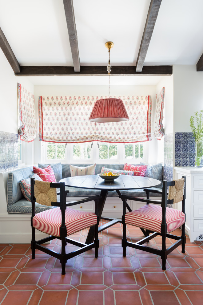 Photo of a mid-sized mediterranean dining room in Los Angeles with terra-cotta floors, red floor and vaulted.