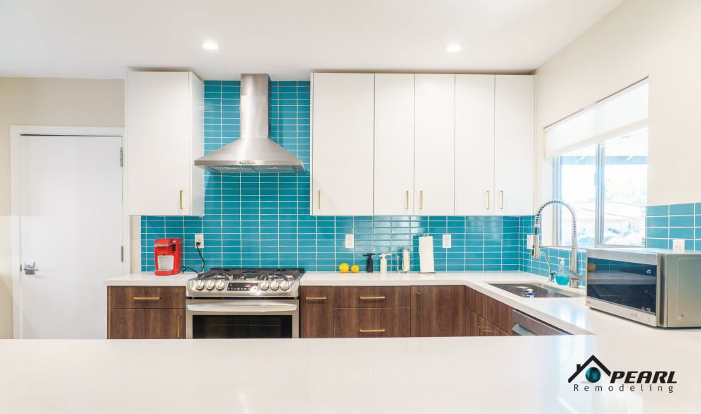 Photo of a large retro u-shaped kitchen pantry in Los Angeles with a built-in sink, flat-panel cabinets, dark wood cabinets, quartz worktops, blue splashback, metro tiled splashback, stainless steel appliances, ceramic flooring, a breakfast bar, beige floors and white worktops.