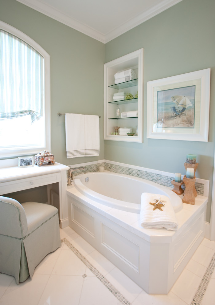 Design ideas for a traditional bathroom in Houston with white cabinets, a drop-in tub and white tile.
