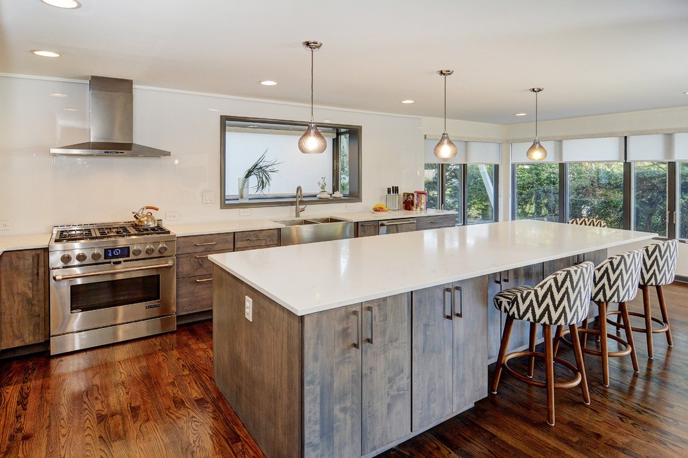 Design ideas for a large contemporary l-shaped eat-in kitchen in San Francisco with a farmhouse sink, flat-panel cabinets, dark wood cabinets, quartz benchtops, white splashback, stainless steel appliances, dark hardwood floors and with island.