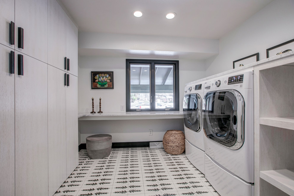 Design ideas for a contemporary galley dedicated laundry room in Denver with flat-panel cabinets, light wood cabinets and a side-by-side washer and dryer.
