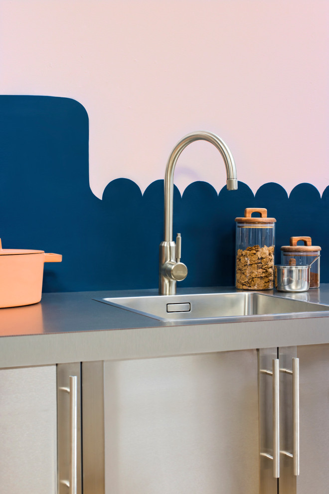 Esempio di una piccola cucina minimalista con lavello a vasca singola, ante lisce, ante in acciaio inossidabile, top in acciaio inossidabile, paraspruzzi blu, elettrodomestici in acciaio inossidabile e top bianco