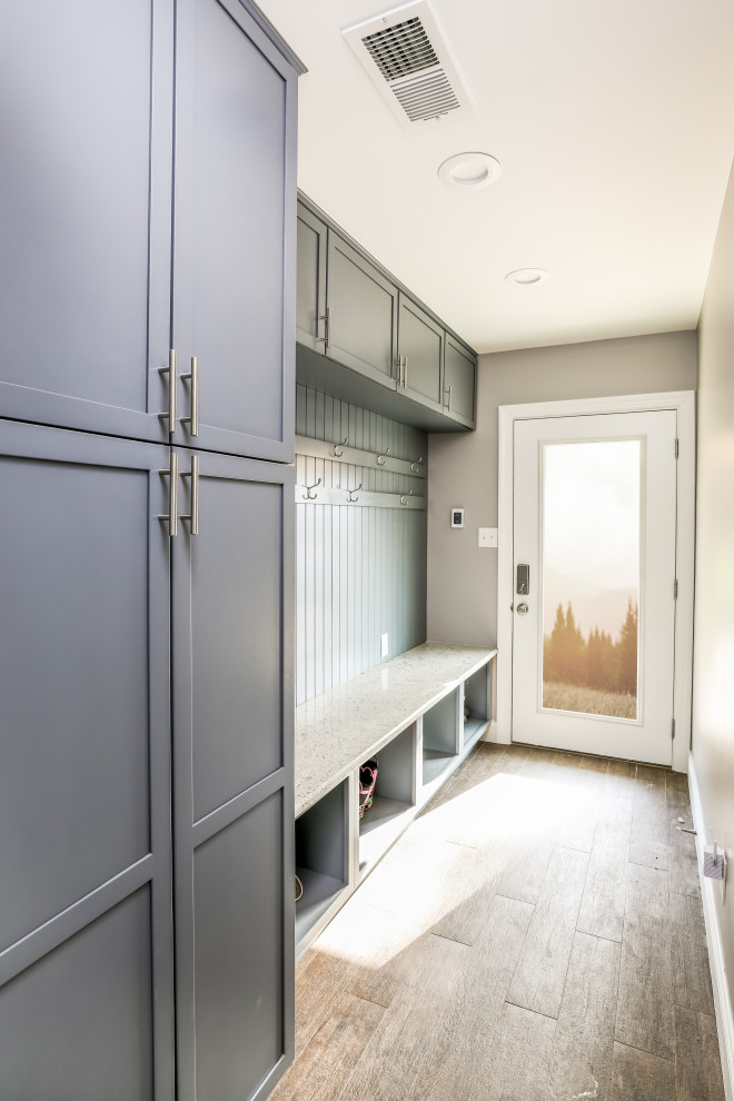 This is an example of a mid-sized transitional mudroom in DC Metro with grey walls, light hardwood floors, a single front door, a white front door and beige floor.