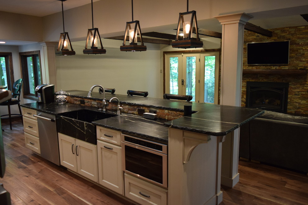 Inspiration for a large transitional galley medium tone wood floor kitchen remodel with an undermount sink, recessed-panel cabinets, white cabinets, quartz countertops, multicolored backsplash, stone slab backsplash, stainless steel appliances and an island