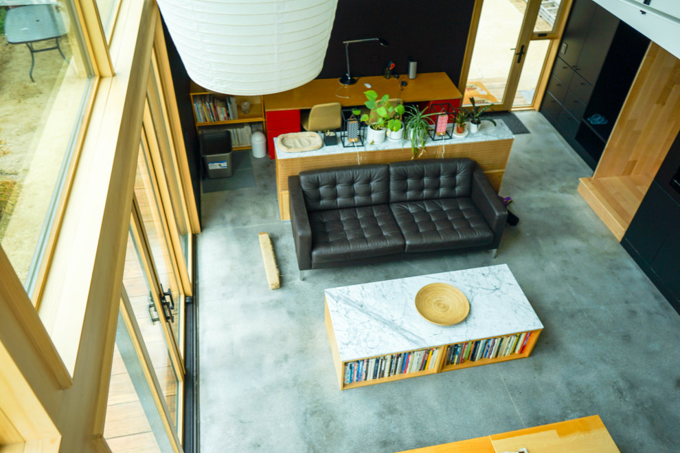 Modelo de biblioteca en casa tipo loft, abovedada y gris y negra nórdica de tamaño medio con televisor colgado en la pared, suelo gris, paredes negras y suelo de baldosas de cerámica