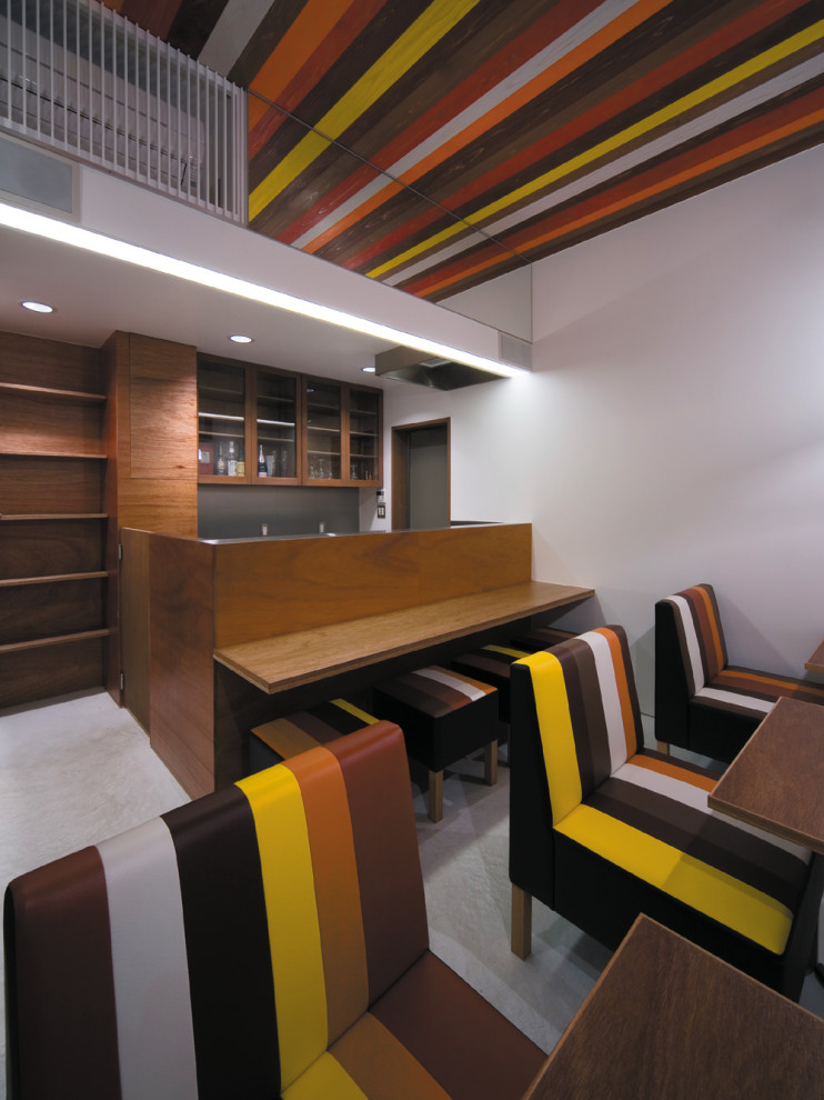 Ispirazione per un piccolo angolo bar moderno con lavello integrato, ante in legno bruno, top in acciaio inossidabile, pavimento in cemento, pavimento grigio e top marrone