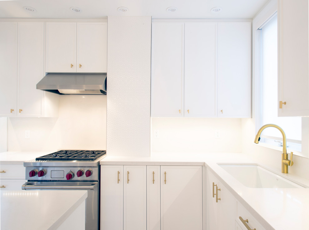 Example of a mid-sized transitional l-shaped light wood floor eat-in kitchen design with an undermount sink, recessed-panel cabinets, white cabinets, quartz countertops, stainless steel appliances and an island