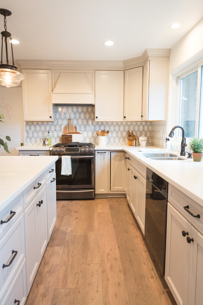 Design ideas for a large transitional u-shaped kitchen in Seattle with an undermount sink, recessed-panel cabinets, grey cabinets, quartzite benchtops, blue splashback, mosaic tile splashback, stainless steel appliances, medium hardwood floors and with island.