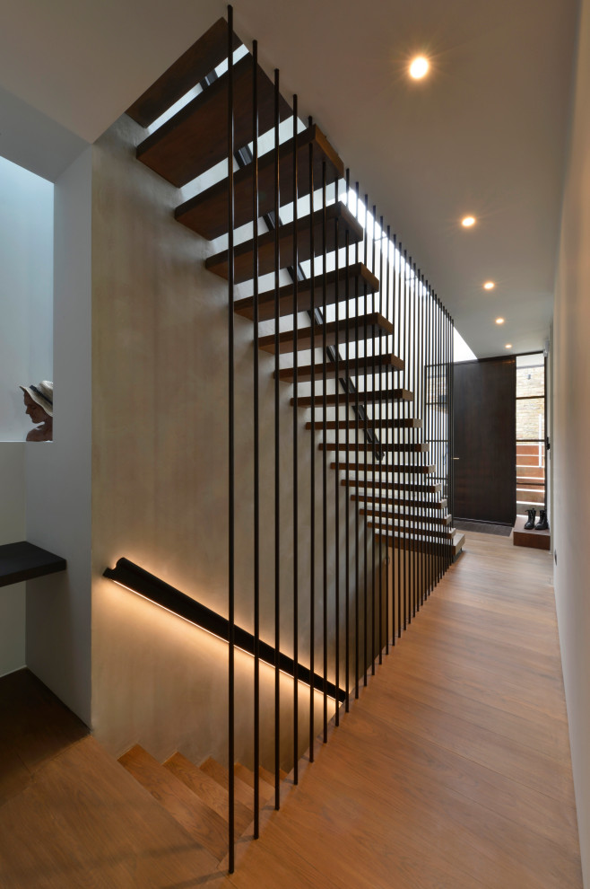 Large contemporary wood straight staircase in London with open risers and wood railing.