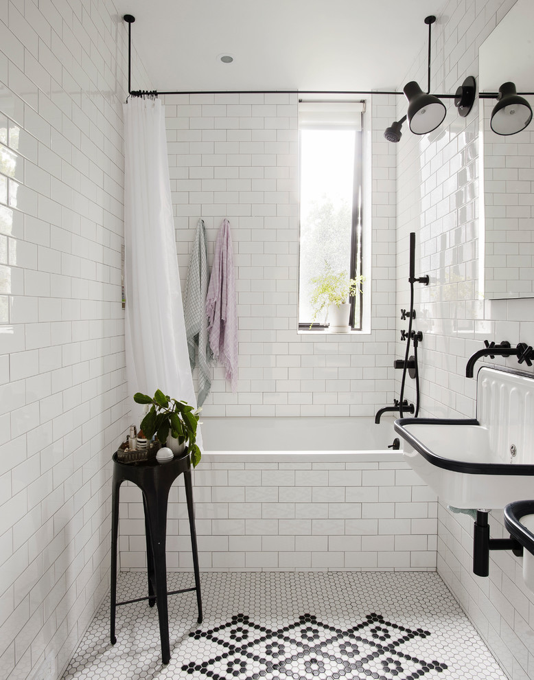 This is an example of a transitional bathroom in New York with an alcove tub, a shower/bathtub combo, white tile, subway tile, a wall-mount sink, multi-coloured floor and a shower curtain.