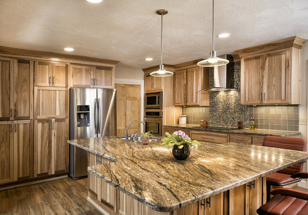 Kitchen - mid-sized transitional l-shaped porcelain tile and brown floor kitchen idea with an undermount sink, shaker cabinets, light wood cabinets, granite countertops, brown backsplash, glass tile backsplash, stainless steel appliances and an island