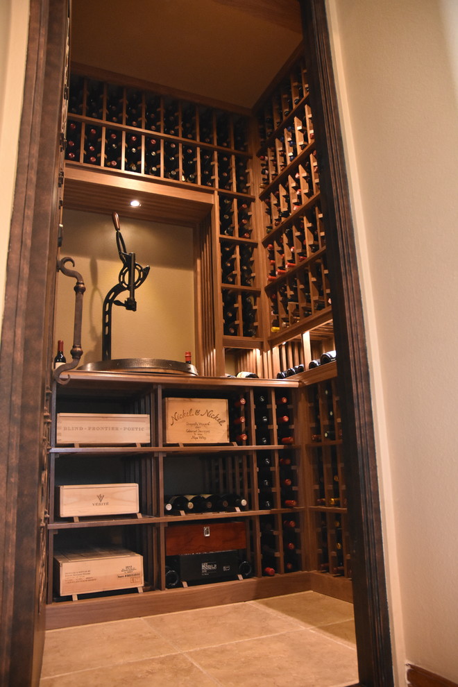 This is an example of a small scandinavian wine cellar in Orange County with ceramic floors and display racks.