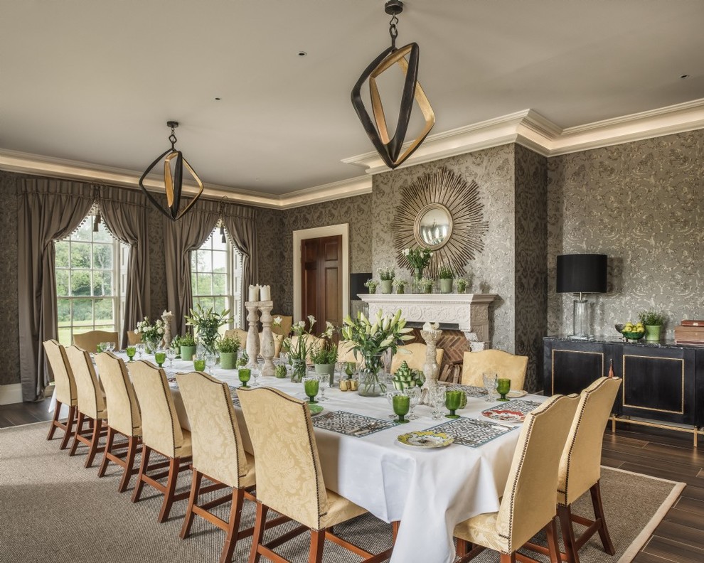 This is an example of a traditional dining room in Surrey with grey walls, a standard fireplace and brown floor.