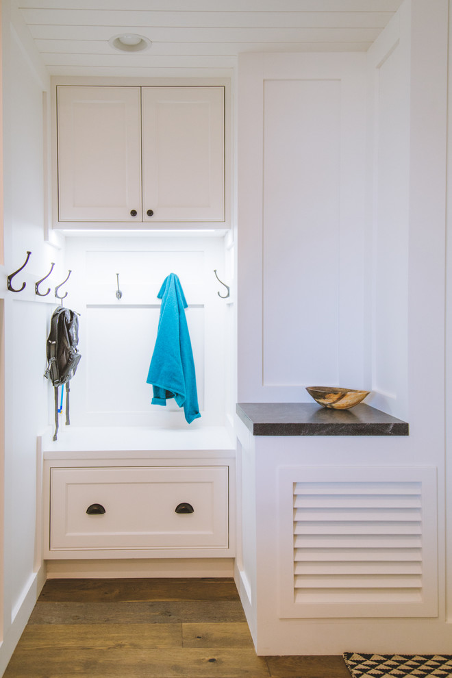 This is an example of a mid-sized country mudroom in Orange County with white walls, medium hardwood floors and brown floor.