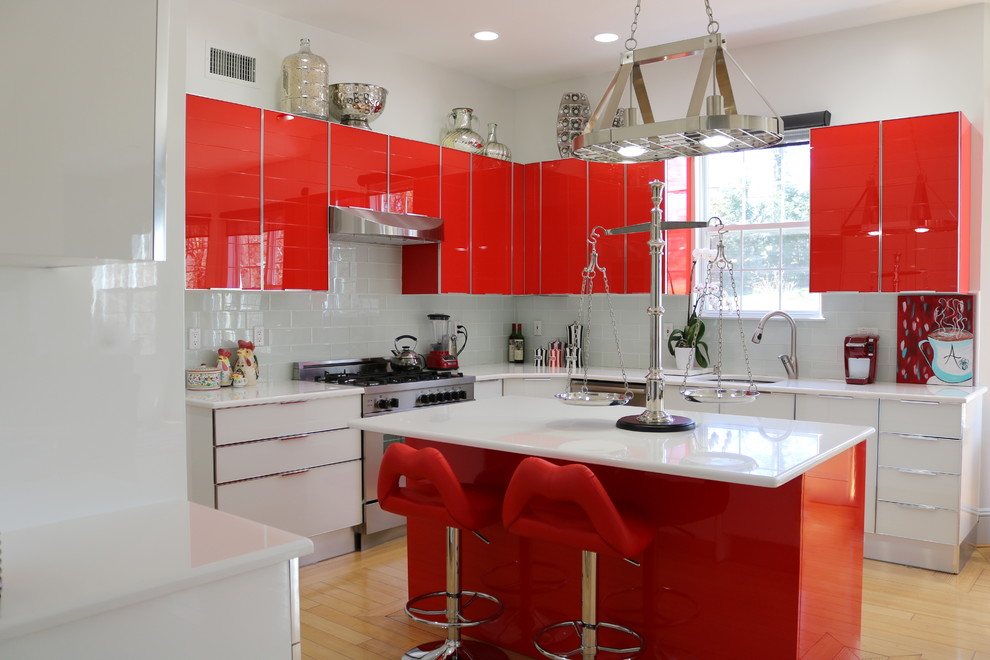 Mid-sized contemporary eat-in kitchen in New York with a drop-in sink, flat-panel cabinets, red cabinets, quartz benchtops, blue splashback, ceramic splashback, stainless steel appliances, light hardwood floors, with island and brown floor.