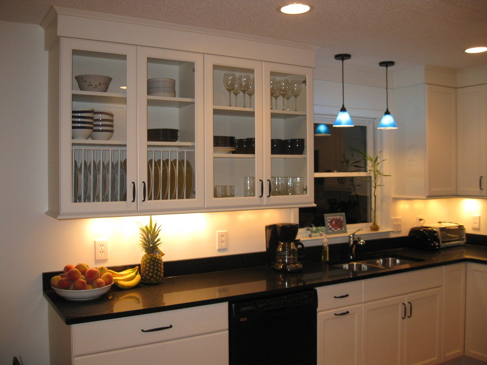 Small transitional l-shaped light wood floor eat-in kitchen photo in Charlotte with an undermount sink, recessed-panel cabinets, white cabinets, granite countertops, black appliances, beige walls and no island