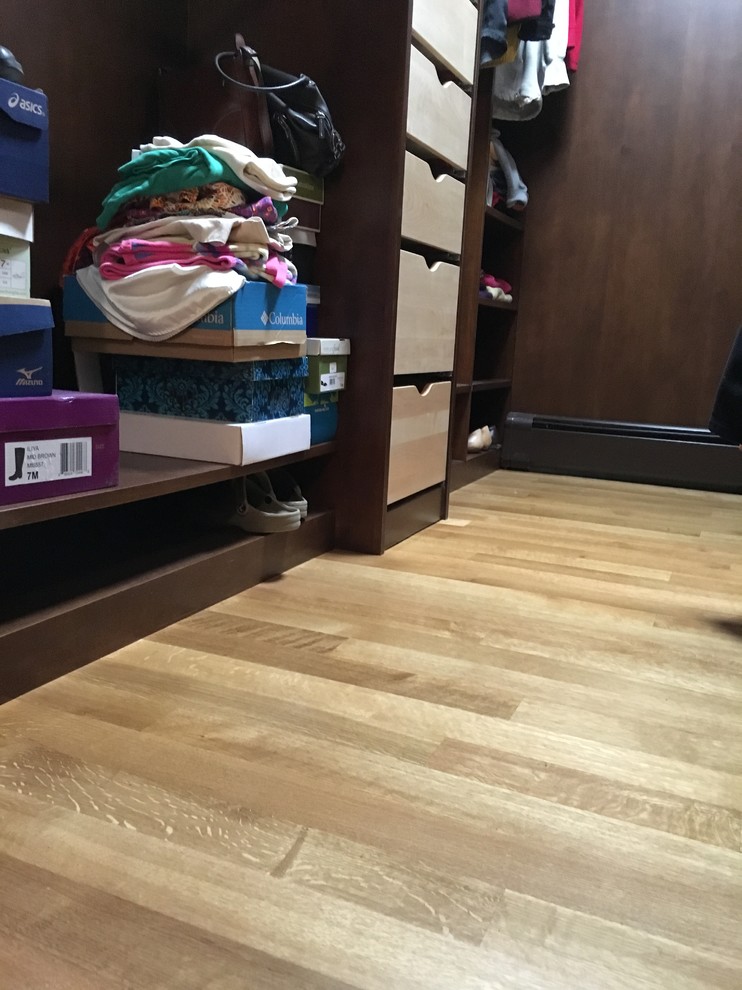 Example of a mid-sized transitional light wood floor walk-in closet design with open cabinets and dark wood cabinets