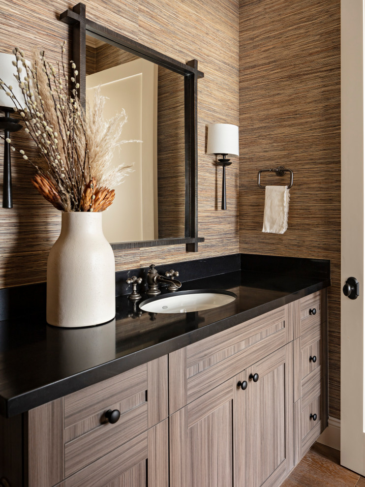 This is an example of a mid-sized transitional kids bathroom in Phoenix with shaker cabinets, brown cabinets, a freestanding tub, an open shower, a one-piece toilet, beige tile, marble, beige walls, light hardwood floors, an undermount sink, engineered quartz benchtops, beige floor, a hinged shower door and black benchtops.