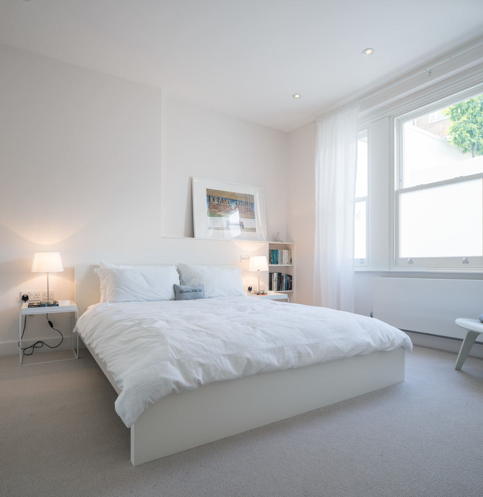 Contemporary bedroom in London with white walls and carpet.