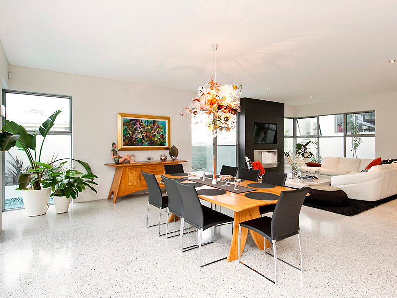 This is an example of a large contemporary open plan dining in Perth with white walls, concrete floors, a standard fireplace and grey floor.