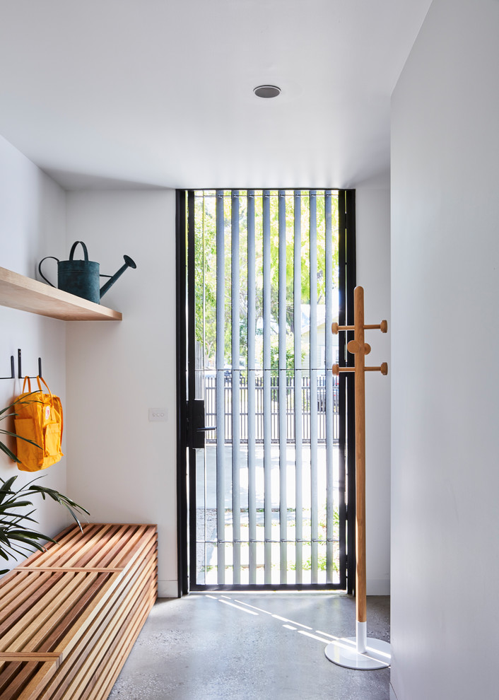 Inspiration for a contemporary mudroom in Melbourne with white walls, concrete floors, a single front door, grey floor and a glass front door.