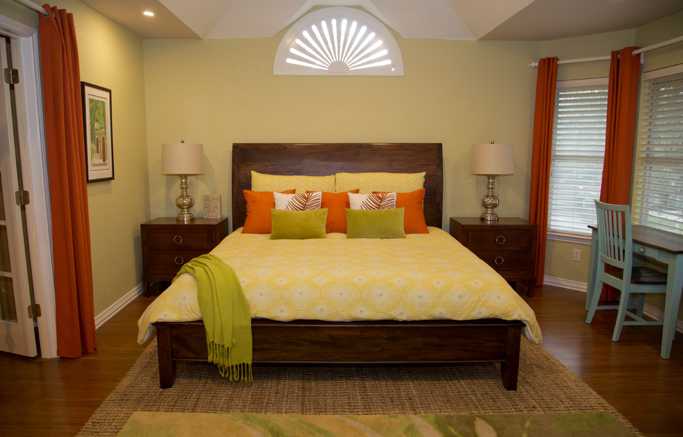 Photo of a mid-sized tropical master bedroom in Austin with green walls, bamboo floors, no fireplace and brown floor.
