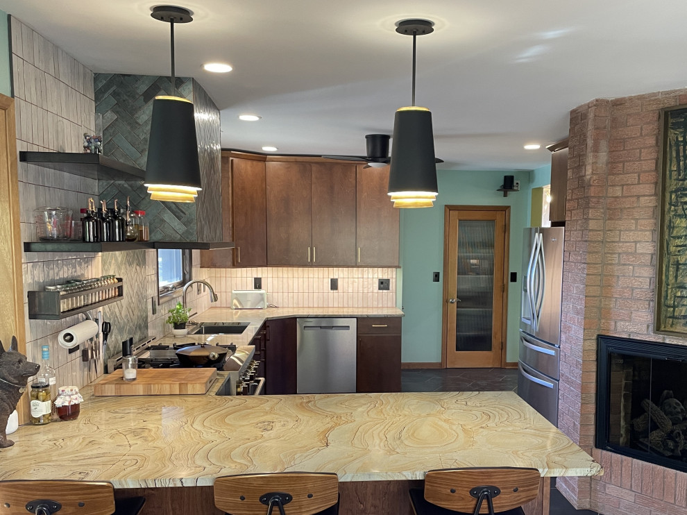 Foto på ett mellanstort 50 tals grön kök, med en undermonterad diskho, öppna hyllor, skåp i mellenmörkt trä, bänkskiva i kvartsit, grönt stänkskydd, stänkskydd i porslinskakel, rostfria vitvaror, klinkergolv i keramik, en halv köksö och svart golv