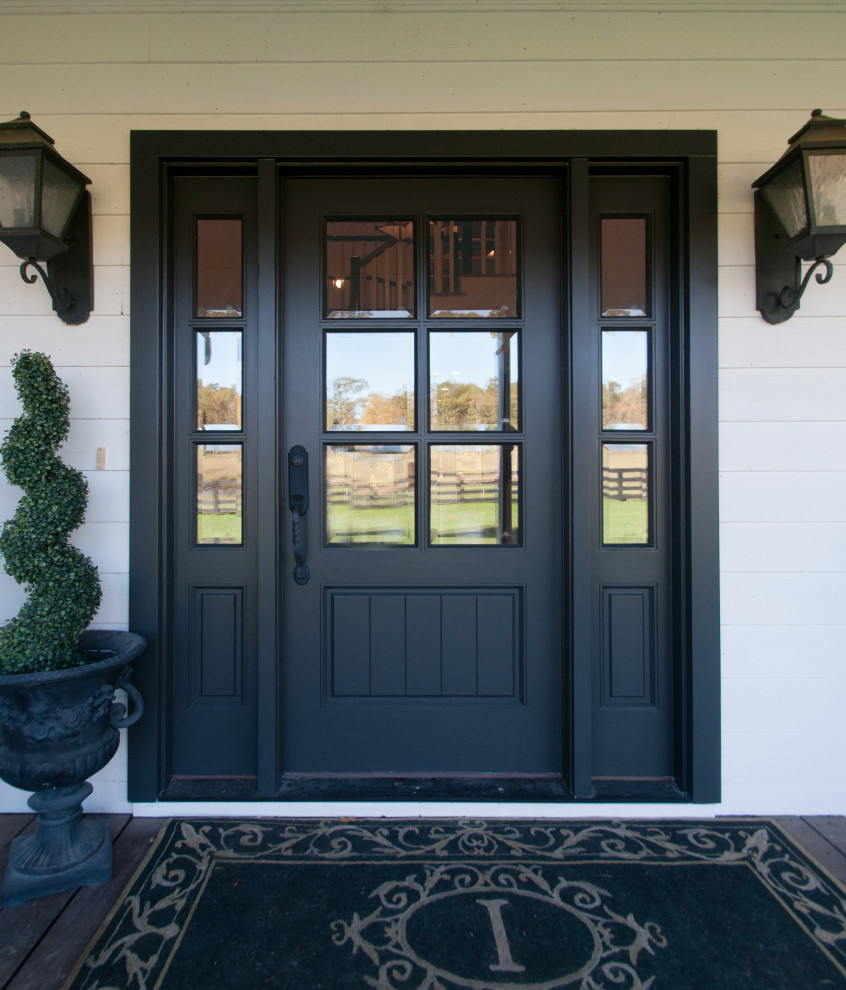 Пример оригинального дизайна: маленькое фойе в стиле кантри с белыми стенами, паркетным полом среднего тона, одностворчатой входной дверью, черной входной дверью и коричневым полом для на участке и в саду