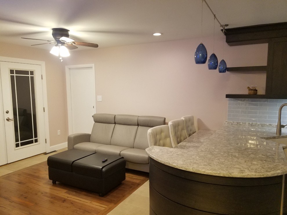 Example of a large transitional l-shaped porcelain tile and beige floor eat-in kitchen design with a farmhouse sink, shaker cabinets, black cabinets, quartz countertops, blue backsplash, ceramic backsplash, stainless steel appliances, a peninsula and white countertops