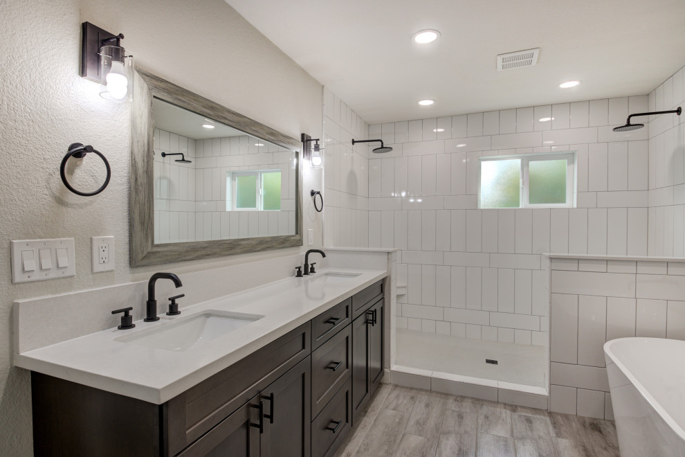 Example of a mid-sized transitional master white tile and subway tile porcelain tile, gray floor and double-sink freestanding bathtub design in Phoenix with shaker cabinets, brown cabinets, an undermount sink, quartz countertops, white countertops and a built-in vanity