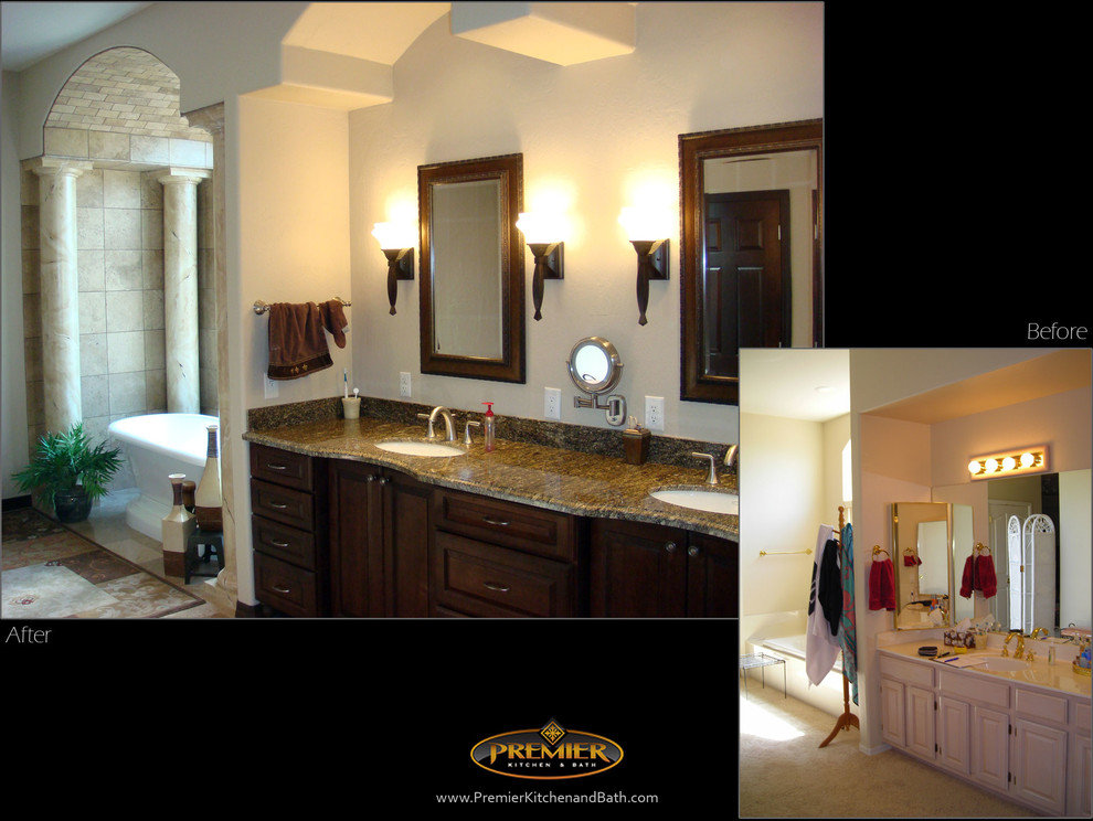 Large mediterranean bathroom in Phoenix with an undermount sink, recessed-panel cabinets, dark wood cabinets, granite benchtops, a freestanding tub, beige tile, stone tile, white walls and travertine floors.
