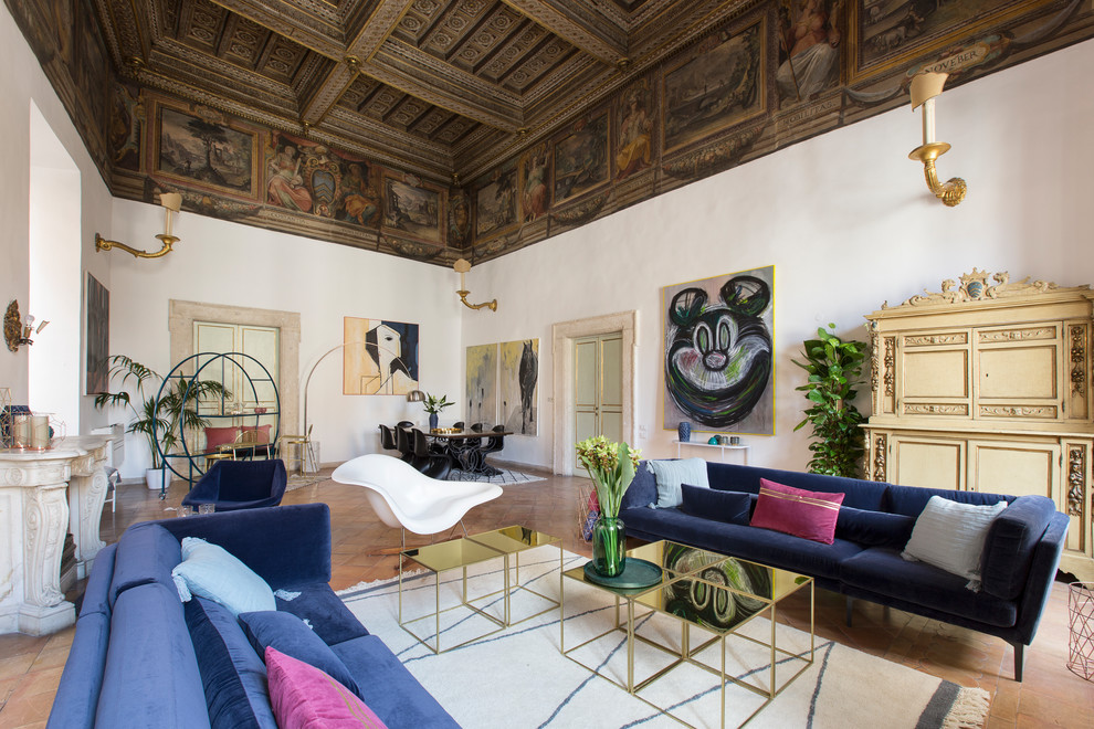 Design ideas for an eclectic formal open concept living room in Rome with white walls, terra-cotta floors, a standard fireplace and orange floor.