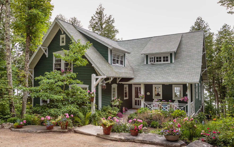 Inspiration for a large traditional two-storey green house exterior in Milwaukee with wood siding, a gable roof and a shingle roof.